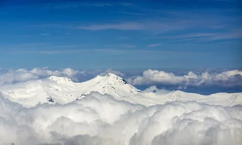 View through clouds at mountain peaks. Fantastic terrific natural landscape. Use Stock Photos