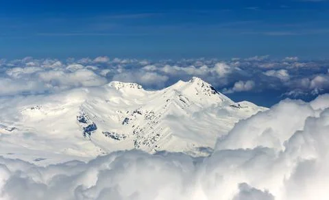 View through clouds at mountain peaks. Fantastic terrific natural landscape. Use Stock Photos