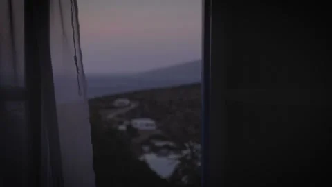 View through the curtain of a window at dusk on a Greek island Vídeos de archivo 330252065