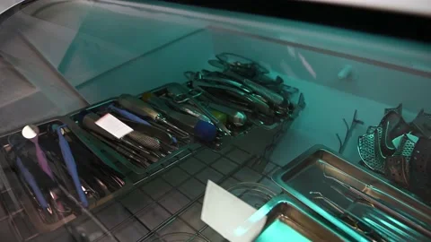 View through dark glass on dentist instruments in metal trays in an autoclave Stock Footage 229989864