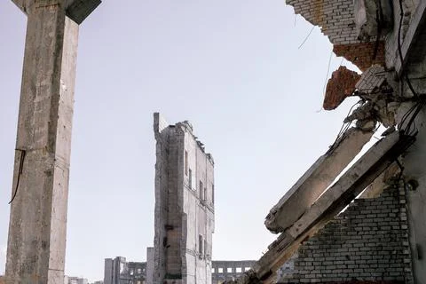 View through the destroyed wall on the remains of buildings against the backg Stock Photos
