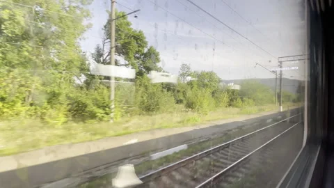 View through the dirty window on countryside panorama while riding on commuter Stock Footage 303364821