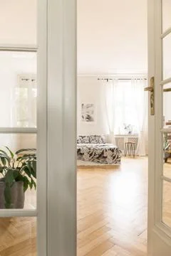 View through door to spacious bright bedroom interior with patterned bed and  写真素材