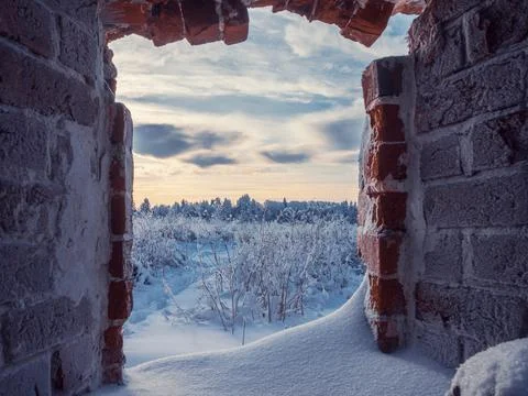 View through an empty window of old ruined brick building. Stock Photos