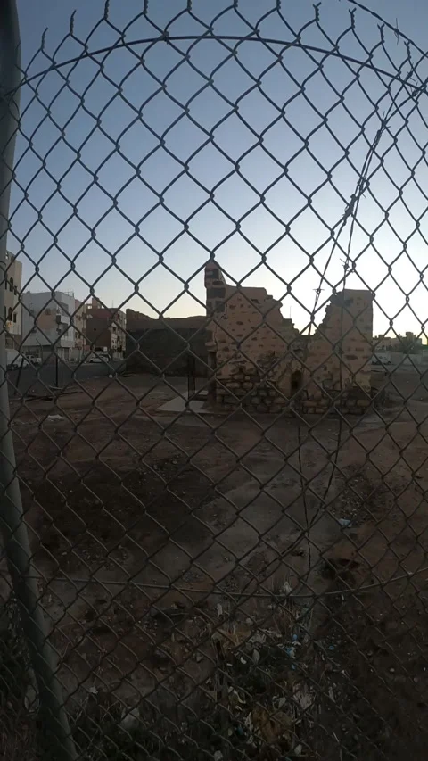 View Through Fence of Ancient Stone Ruins at Dusk Stock Footage 346534345