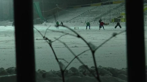 The view through the fence snow-covered stadium   and training hockey players. Stock Footage 59049372