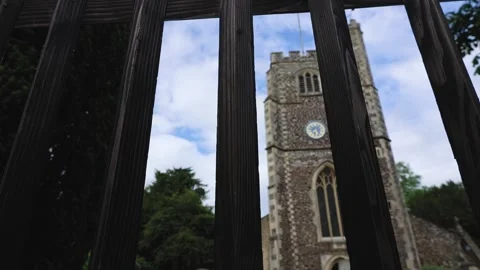 View Through The Fence Of The Tower Of An Old English Church With A Clock Stock Footage 305426724