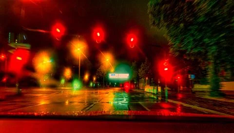 View through a front window of a car at the night stop at a colorful reflecting Stock Photos