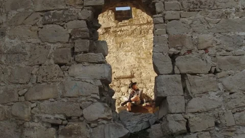 View through a gap in the ancient fortress wall to a charismatic gentleman Stock Footage 279224225