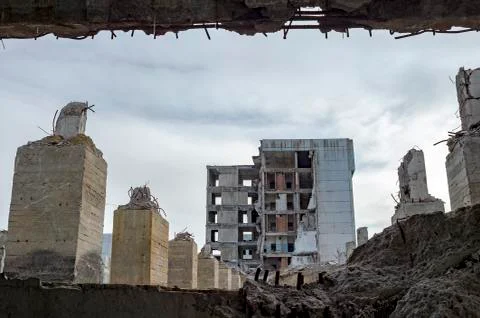 View through a gap in the concrete wall with protruding rebar on the remains  Stock Photos