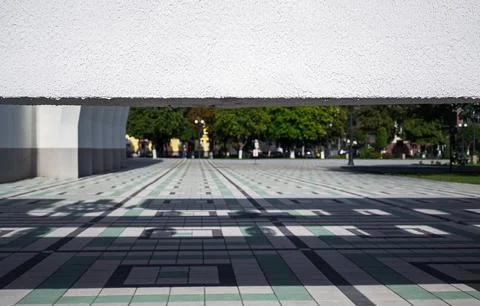 View through geometric concrete building structure on empty public square with Stock Photos