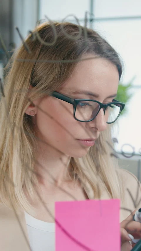 View through glass wall on attractive concentrated skilful successful female wor Stock Footage 329187294