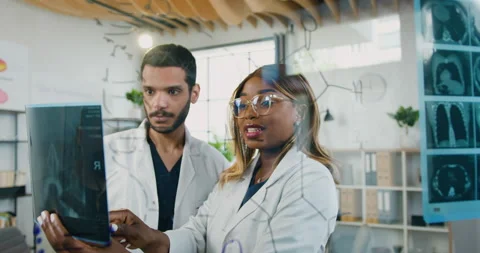 View through glass wall on confident skilled multiracial two medical workers Stock Footage 158113885