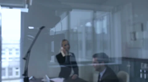 View through glass of workers in an office Stock Footage