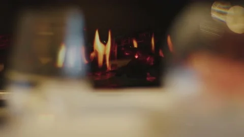 View through glasses on the fireplace with a burning flame Stockbeeldmateriaal 223001987