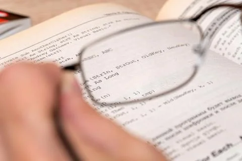 View through glasses in hand on a text in the book Foto stock