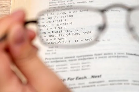 View through glasses in hand on a text in the book Stock Photos
