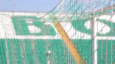 View through goal net on empty stadium seats Stock Footage 73704063