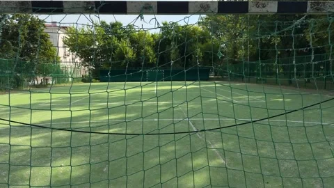 View through green net at empty artificial turf football court 動画素材 338361707