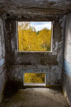 View through the hole for a windows in a damaged abandoned panel house. Stock Photos