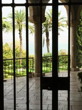 View through the iron gate on the garden of the church of beatitude Stock Photos