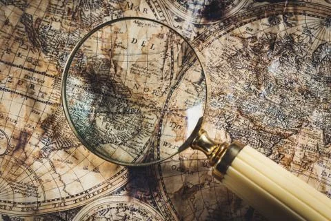 View through magnifier on old map, showing "America" word. Stock Photos