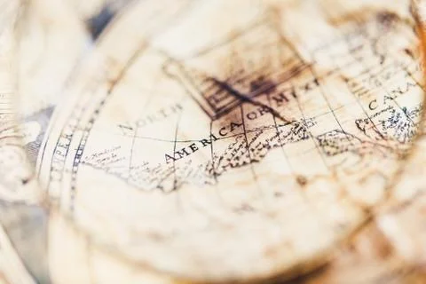 View through magnifier on old map, showing "America" word. Stock Photos