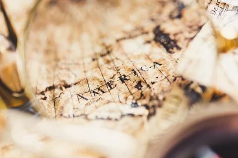 View through magnifier on old map, showing "America" word. Stock Photos