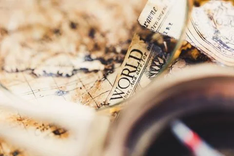 View through magnifier on old map, showing "World" word. Stock Photos