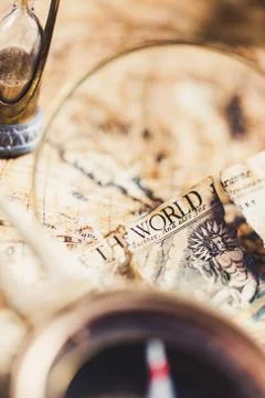 View through magnifier on old map, showing "World" word. Stock Photos
