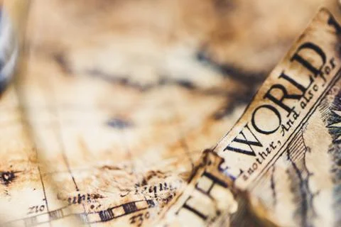 View through magnifier on old map, showing "World" word. Stock Photos