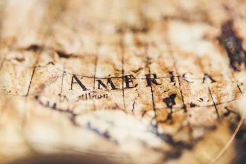 View through magnifier on old map, showing "America" word. Stock Photos