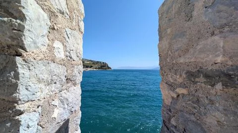 A view through a medieval fortress window loop looking out over the clear b.. Stock Photos