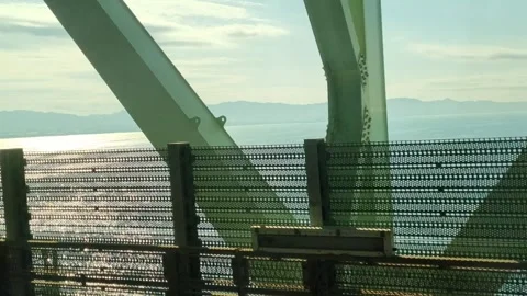 View through a metal mesh security fence on a bridge overlooking the sea. S.. Stock Footage 325633654