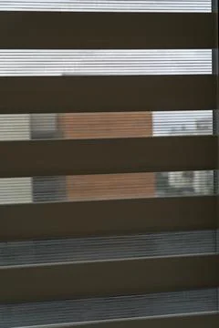 View through modern window blinds revealing an urban landscape with a hint of Stock Photos