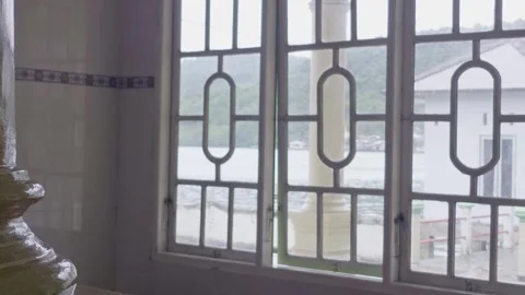 View through mosque window showing coastal village scenery in Ngafan Vídeos de archivo 332715531