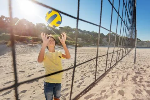 View through the net of boy playing volleyball Stock Photos