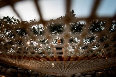 View through the net of man standing on trampoline 스톡 사진