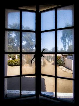 View through an old window frame to a sunny courtyard Fotos de archivo