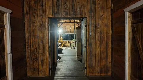 View through an open doorway in a rustic wooden cabin at night. Foto stock