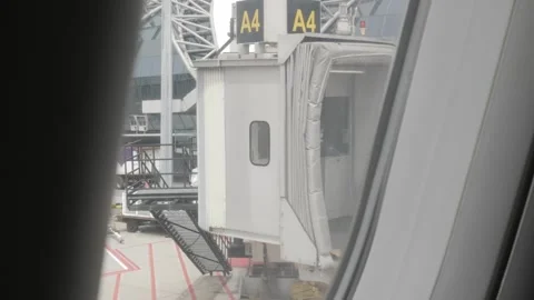 View through plane window to the jetbridge Stock Footage 283054120