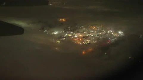 View Through Plane Window on a Night City Lights and Misty Clouds While Landing Video stock 202327514