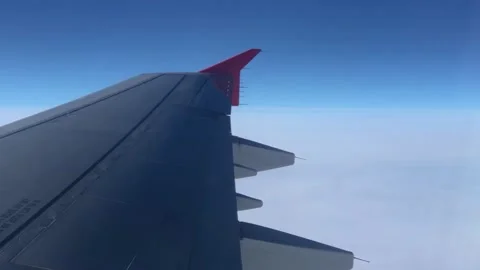 View through the porthole on the wing and clouds. Airplane wing through the Stock Footage 204854229
