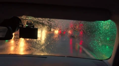 View through rainy car windshield during evening city drive Stock Footage 341767348
