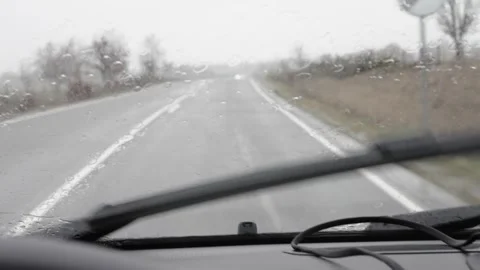 View through a rainy windshield with raindrops. windshield wipers and a car Stock Footage 339353942