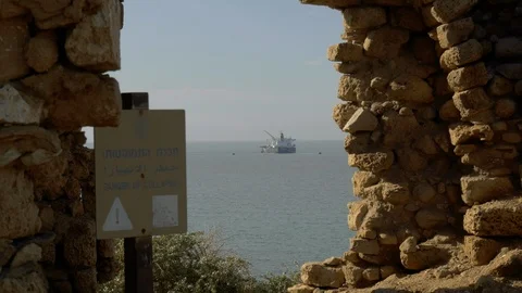 View through the remains of ancient wall, sea tanker at parking Stock Footage 100644851