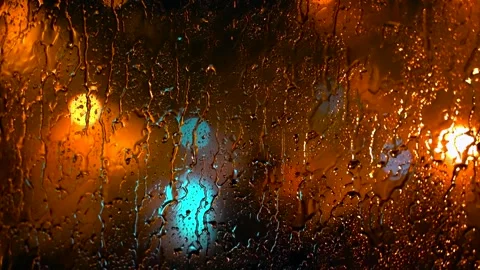 View Through Room Window with Raindrops on Blurred Car Lights on City Street Stock Footage 312866447