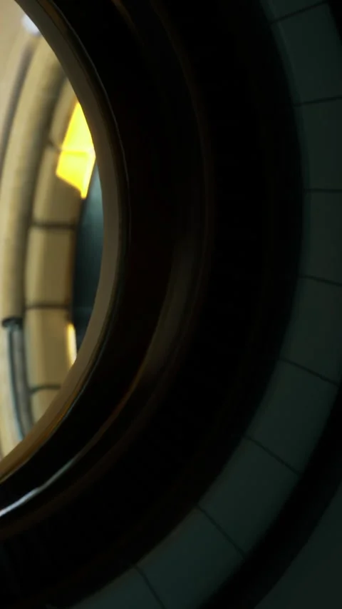View through a round window showing a light source and wall details 스톡 동영상 335093962