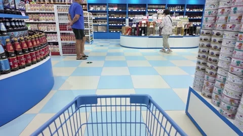 A view through a shopping cart looking down a blue and white tiled aisle in a Stock Footage 287001388