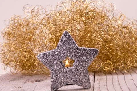 View through the silver star to the flame of a candle Stock Photos